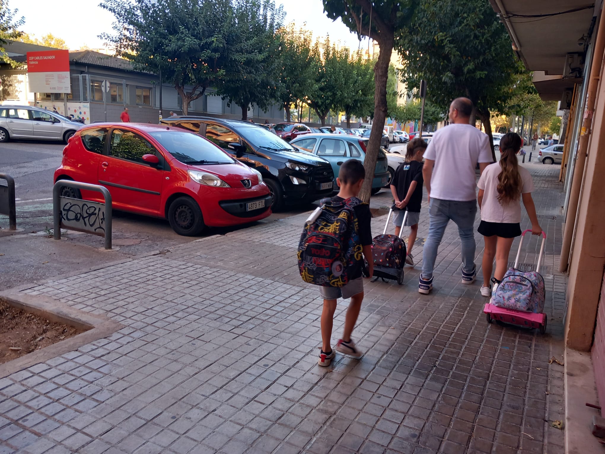 Voluntarias del CEIP Carles Salvador andando por la acera de camino al colegio.